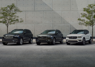 Kolme Volvoa rivissä seinän vieressä